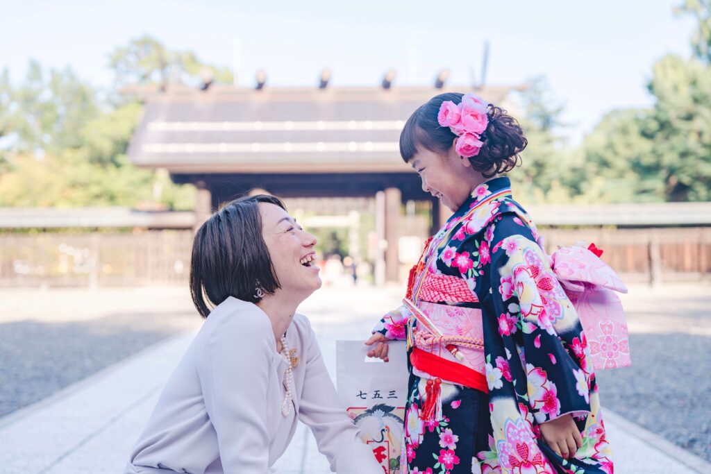 札幌護国神社の境内で顔を見合わせて笑う七五三の女の子とお母さん